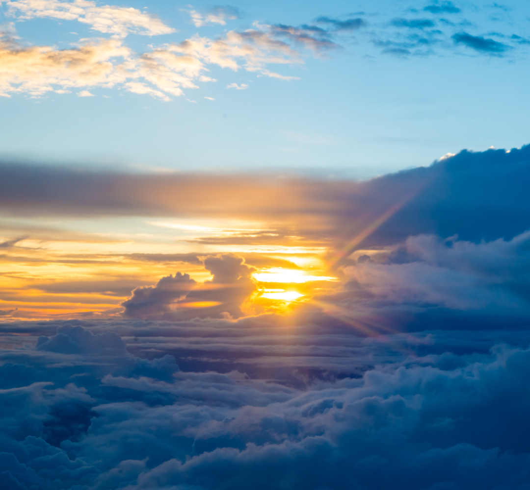 View from airplane window with clouds and sky – illustrating flight pressure impact on piercings