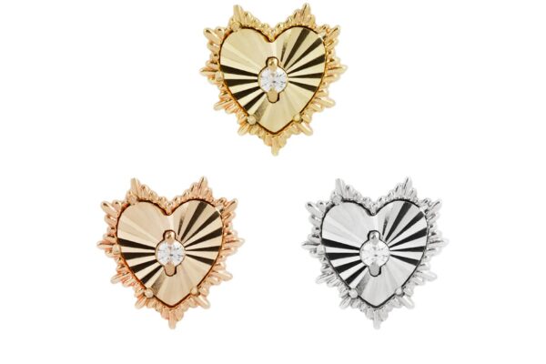The 14K Bad Romance pins feature a heart shape with radiating lines, a small central flower, and textured borders. Available in gold, rose gold, and silver finishes, they evoke a bold romantic style.