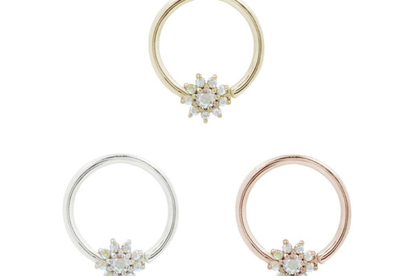 Three 14K Eloise - Seam Rings in gold, silver, and rose gold, each with a central starburst cluster of white gemstones, are arranged in a triangle on a white background.