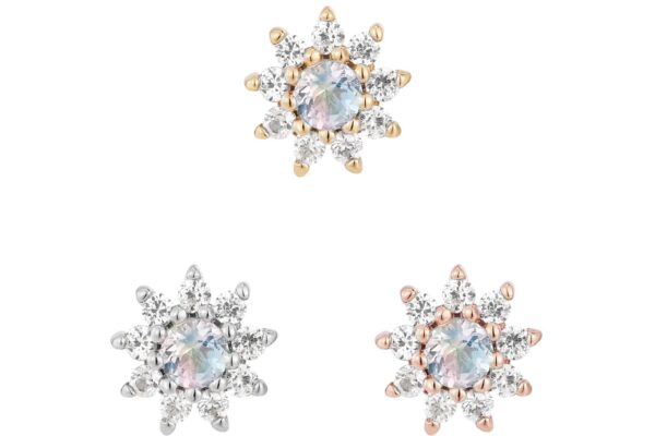 Three flower-shaped stud earrings with central iridescent stones, like the 14K Eloise - Rainbow Moonstone, are accented by clear gem petals. Two have silver details, one gold—all set against a white background.