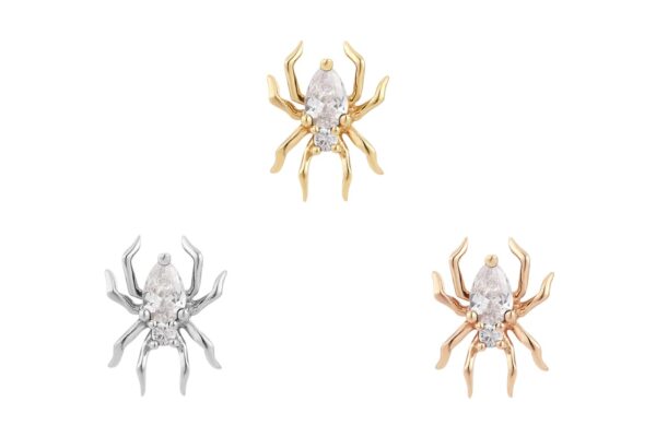 Three spider-shaped stud earrings called 14K Arachne are shown on a white background, in yellow gold, silver, and rose gold finishes. Each features a clear stone at the spider’s body for added sparkle.