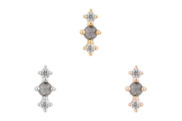 Three small stud earrings with a central round stone and two side stones are shown on a white background: one in gold (14K Ghost Flower), the others in silver and rose gold.