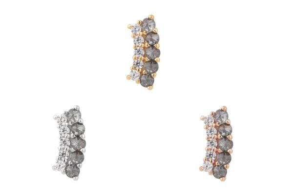 Three 14K Whisper + Shout curved end earrings, each featuring five dark stones and a row of smaller clear stones, are shown in gold (top), rose gold (right), and silver (left) on a white background.