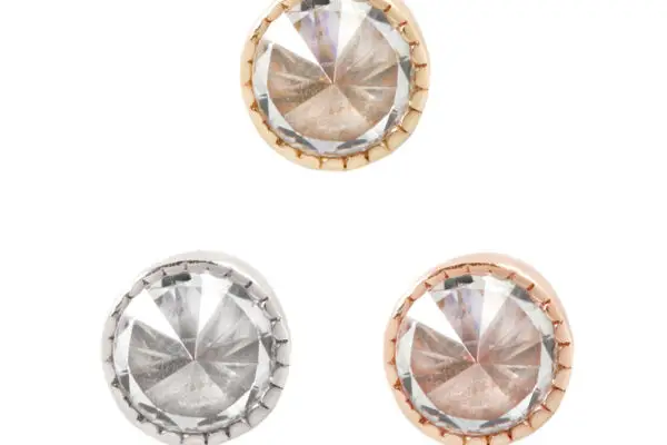 The 14K Milgrain Reverse Set features three round, faceted crystal studs—one gold, one silver, and one rose gold—with milgrain borders, displayed in a triangular arrangement on a white background.