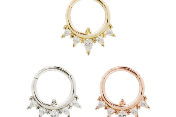 Three 14K Taja - Clicker hoop earrings, each with five teardrop-shaped clear gemstones—one in gold, one in silver, and one in rose gold—are displayed against a white background.