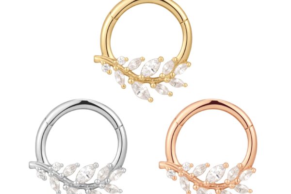 Three decorative hoop earrings are shown: one gold, one silver, and the 14K Wild Soul - Clicker in rose gold. Each features a leafy branch design adorned with small clear gemstones.