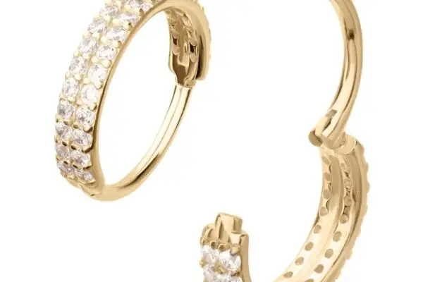 The 14K Double Gem Clicker is a gold hoop earring, partially open, featuring two rows of small, clear round gemstones on its outer surface.