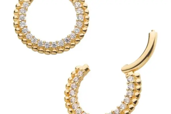 The 14k Beaded Gem Clicker earrings are gold hoops with a beaded outer edge and a half row of sparkling white gemstones for added shine.