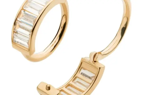 The 14K Baguette Side Clicker features a pair of gold hoop earrings with rectangular clear gemstones set in a row along the front, highlighting their baguette design and secure side clicker clasp, shown from two angles.