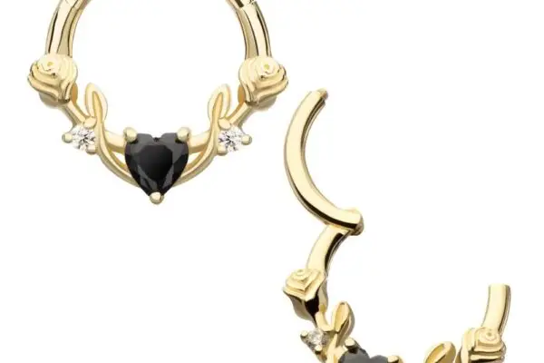 The 14K Rose Heart Clicker features two hoop earrings with a central black heart stone, small white stones, and rose-shaped side details; one earring is closed, the other open.