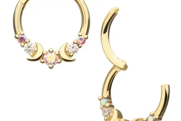 The 14K Round Triple Moon Clicker set features two gold hoop earrings with crescent moon designs, opal center stones, and small sparkling gems arranged symmetrically—one earring closed, the other slightly open.