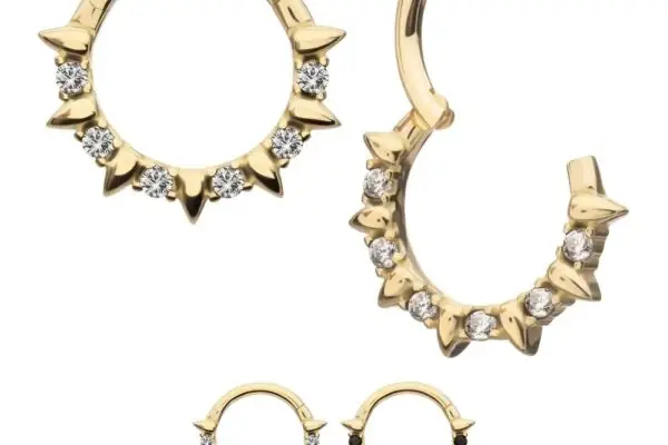 The 14K Gem Spike Clicker earrings, shown in two sizes, feature gold hoops with pointed accents. One is open to reveal the clasp, while another pair showcases bold black stones instead of clear gemstones.