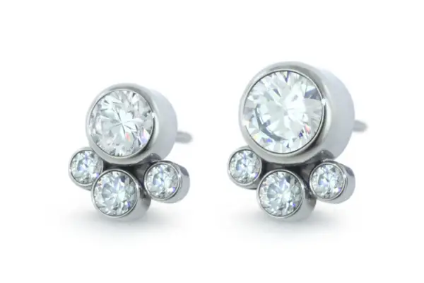 The Bezel Set Faceted Cluster - Tangent earrings are silver studs with a large central Ti Bezel Cz gemstone and three smaller clear stones clustered below.