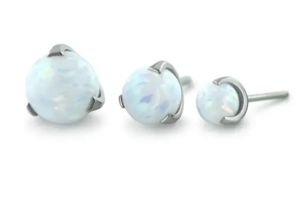 Three Sphere Gem silver stud earrings, each with a round opalescent white stone in increasing sizes, are arranged in a row against a white background.