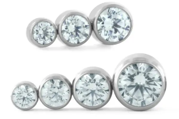 Five round, clear gems in silver bezels form a Ti Bezel Set Gem Cluster - Tapered, arranged in two size-graded rows from left to right on a white background.