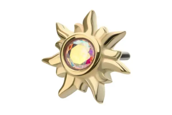 The 14K Sunburst is an earring with a gold sun-shaped design and a rainbow-hued iridescent gem at the center, displayed on a white background.