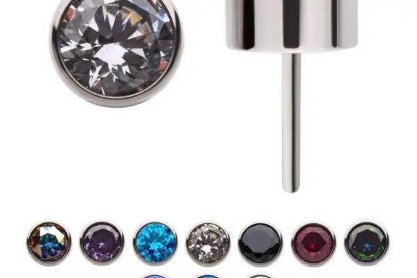 The Bezel Set Top earrings feature round gemstones in clear, purple, blue, black, red, and iridescent white, each set in sleek titanium bezels with silver metal. One earring is shown from the side for added detail.