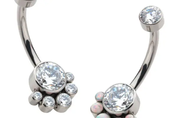 Two Terraced Cluster Navel Curves, each with a silver curved design and central gem—one featuring clear crystals, the other showcasing both clear and opalescent stones.