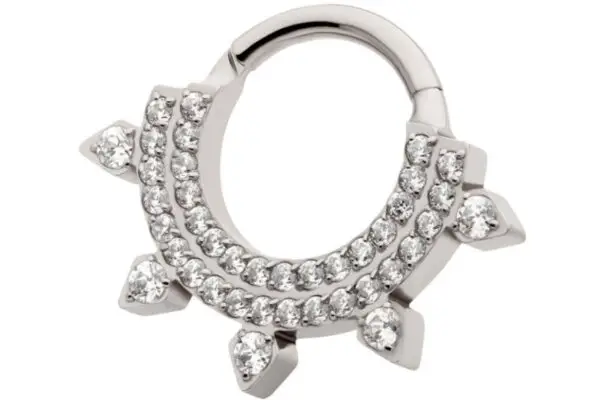 The 5 Spike Clicker is a titanium hoop earring with two rows of clear gemstones and five gemstone-tipped spikes in a crescent shape.