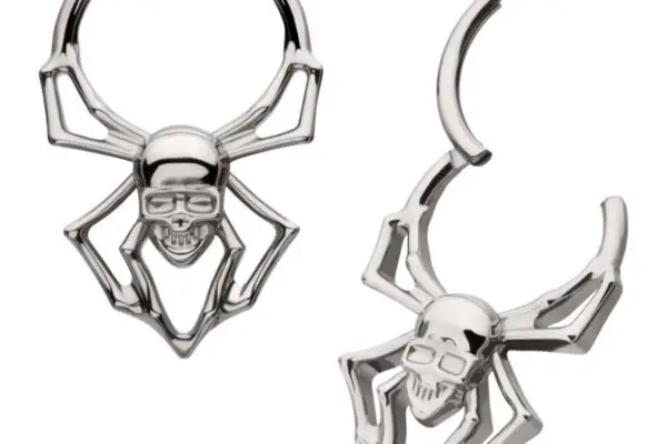 The Skull Spider Clicker is a pair of titanium hoop earrings shaped like spiders with skull bodies, detailed legs, and grinning skull faces.