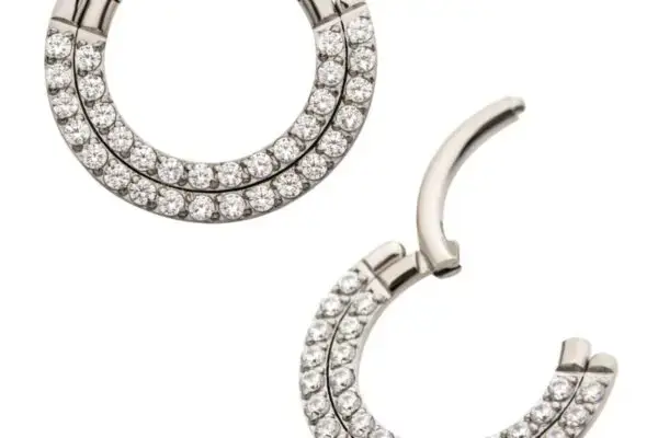 A pair of Double Row Prong Clicker hoop earrings in silver titanium, featuring two rows of clear gemstones; one is shown closed, the other open, on a white background.