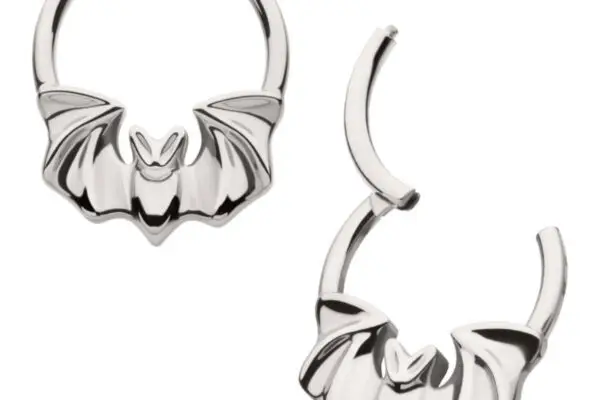 The Flying Bat Clicker features two silver titanium hoop earrings with a bat motif—one earring is closed, and the other is partially open.