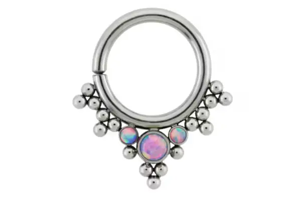 The HSMR-B is a titanium seam ring in silver, showcasing a central iridescent opal-like gem and decorative metallic beads in a triangular pattern.