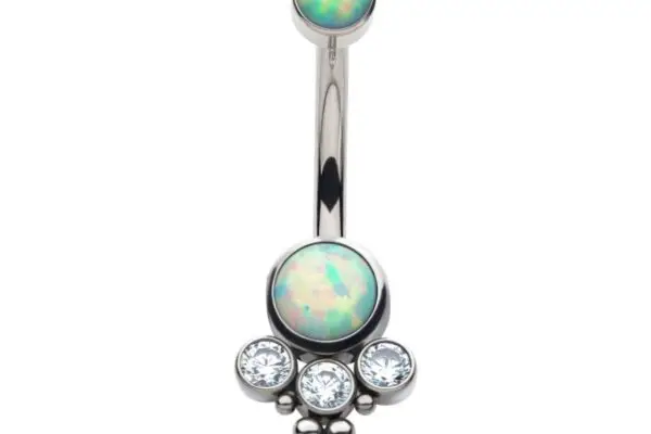 The Tri Bead 3 Gem Navel Ring has a silver design with round opalescent gems at both ends; the larger gem is accented by three clear crystals and three small silver beads beneath it.