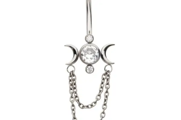 The Triple Moon Dangle belly button ring features a central clear gem, crescent moons on each side, two small round gems, and two dangling chains.
