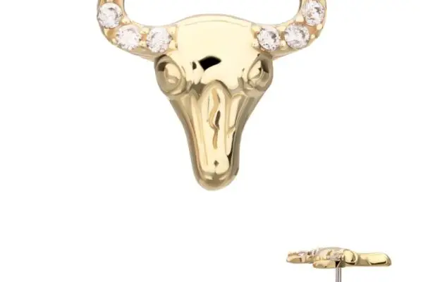The 14K Steer Head stud earring is crafted in gold, shaped like a bull’s head with small clear gemstones set along its horns. The side angle highlights the earring post.