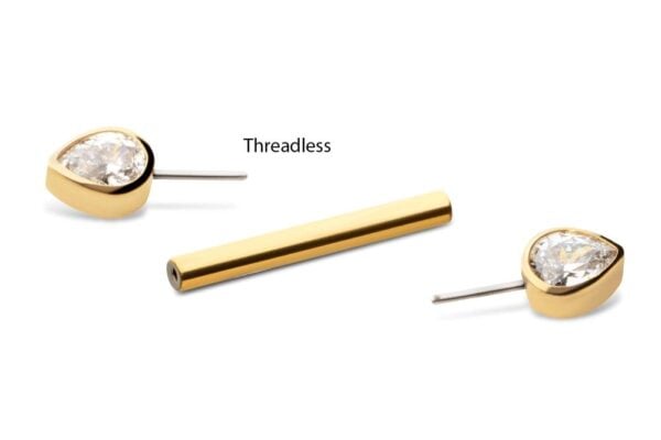 The Teardrop Nipple Barbell, featuring two gold earrings with teardrop-shaped clear stones and a separate gold cylindrical bar labeled “Threadless,” is displayed on a white background.