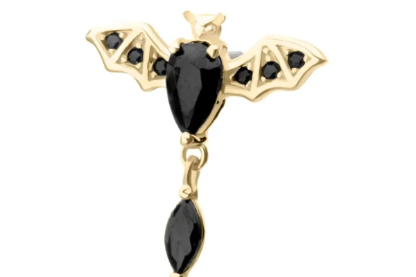 The 14K Flying Bat-Marquise Dangle is a gold, bat-shaped earring adorned with black gemstones on its wings and body, finished with a single dangling black gemstone below.