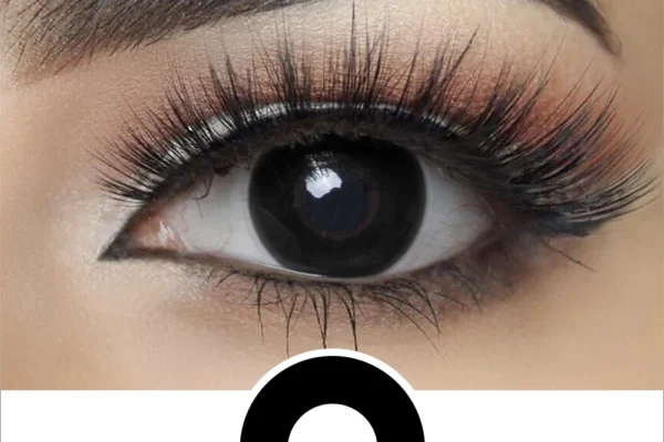 A close-up of a person’s eye with dramatic makeup and thick lashes wearing Magister - Black Out contacts, shown above a bold black circle centered on a white background.