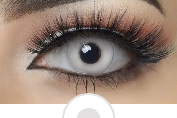 A close-up of an eye with dramatic makeup and long lashes, showcasing Magister - White Out lenses that fully cover the iris and pupil for a bold, otherworldly look.