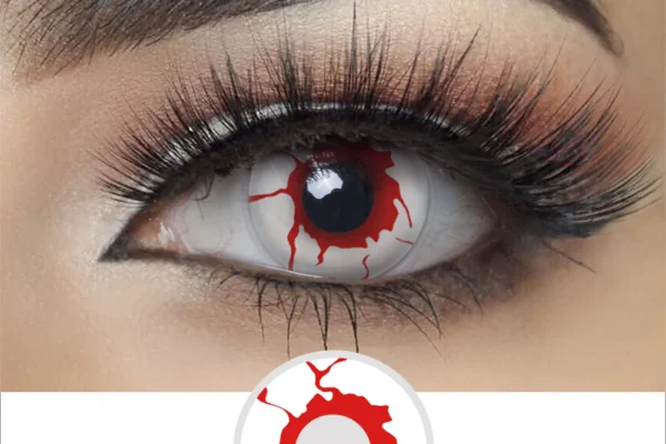 A close-up of an eye wearing Magister - Blood Shot contacts, showing a white base with red veins radiating from the pupil for a cracked, bloodshot effect. Thick lashes and a defined brow enhance the dramatic look.