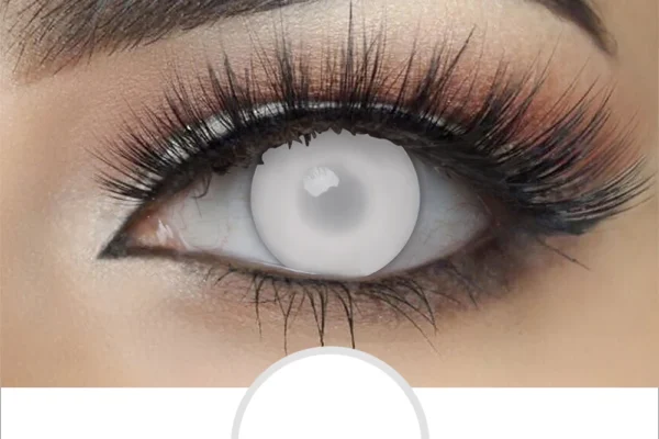 A close-up of an eye with dramatic makeup and long false lashes, wearing Magister- Blind White contacts that are light gray, almost white, fully covering the iris and pupil.