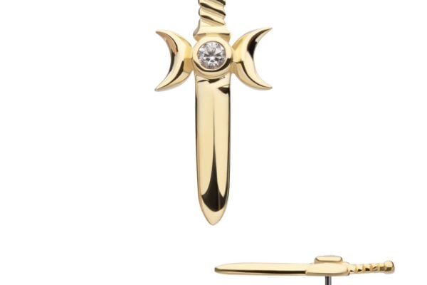 The 14K Triple Moon Dagger earring, shaped like a gold sword with crescent moons on each side and a clear center gemstone, is shown from front and side views against a white background.