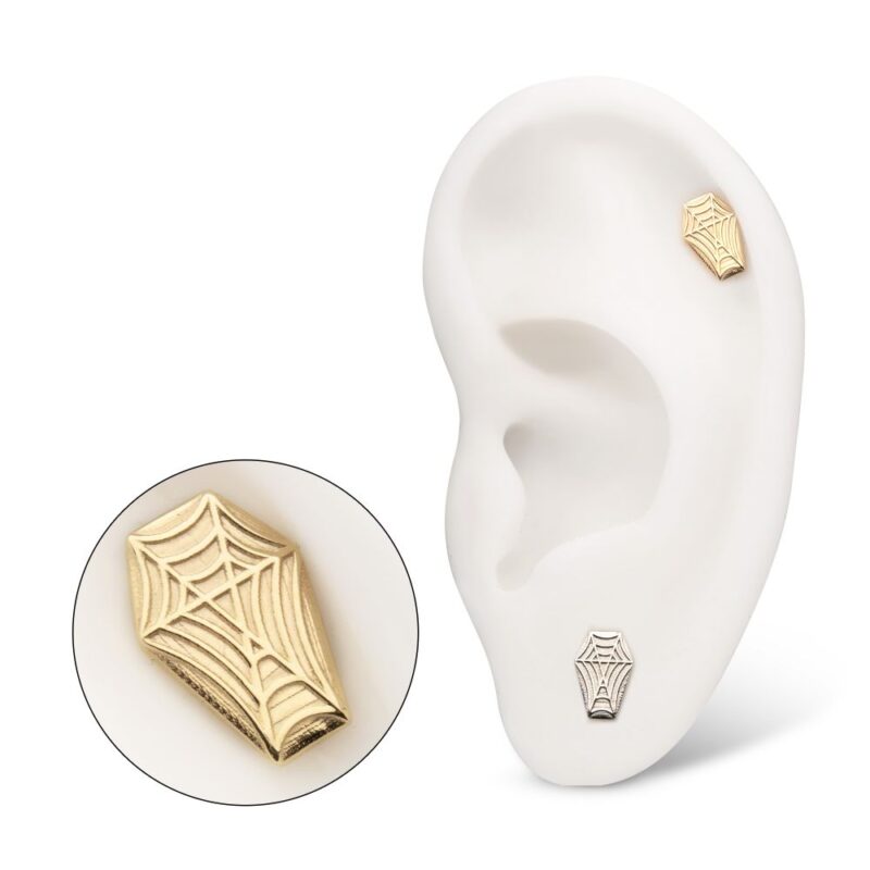 A white model ear displays two 14K Spiderweb Coffin earrings, one gold and one silver. A close-up highlights the intricate spiderweb design on the gold earring.