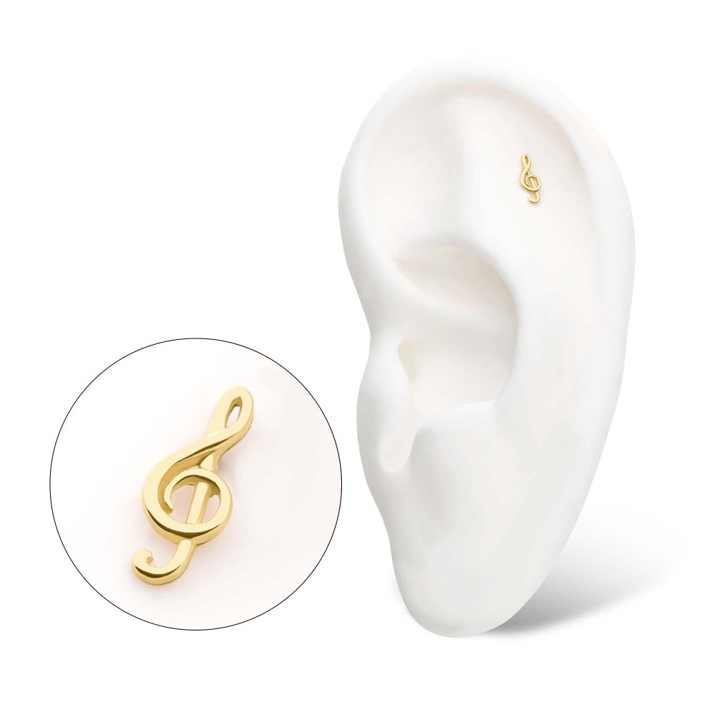The 14K G Clef Musical Symbol earring is shown beside a white model ear, which wears the same gold treble clef earring in the upper cartilage. The 14K G Clef Musical Symbol earring is shown beside a white model ear, which wears the same gold treble clef earring in the upper cartilage.