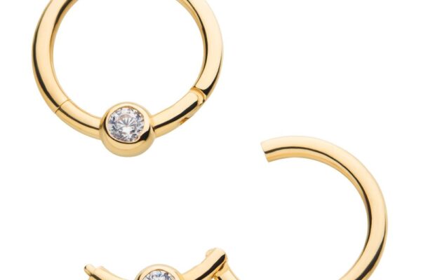 Two gold hoop earrings, each featuring a single clear gemstone set in the center, with one earring closed and the other partially open to show the clasp mechanism.