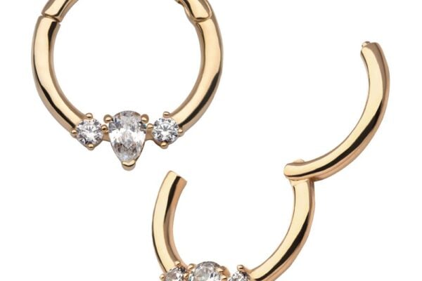 The 14K Pear Clicker features two gold hoop earrings, each with a central teardrop-shaped gemstone and two smaller round gems. One earring is closed, while the other is open to display the clasp mechanism.