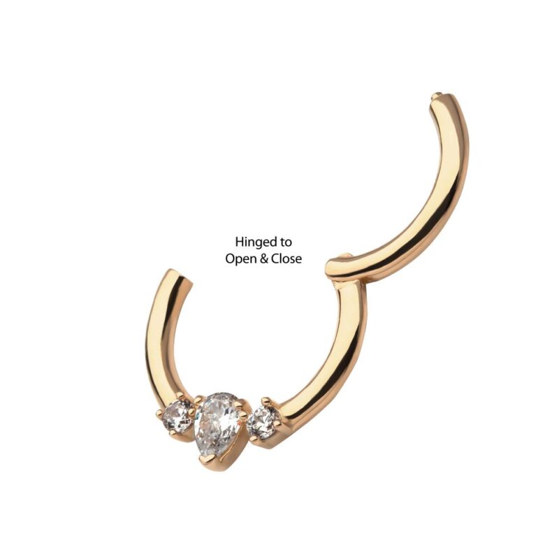 The 14K Pear Clicker is a gold hinged hoop earring featuring three clear gemstones at the base. Shown open to highlight its Hinged to Open & Close mechanism, with the text pointing to the hinge section.
