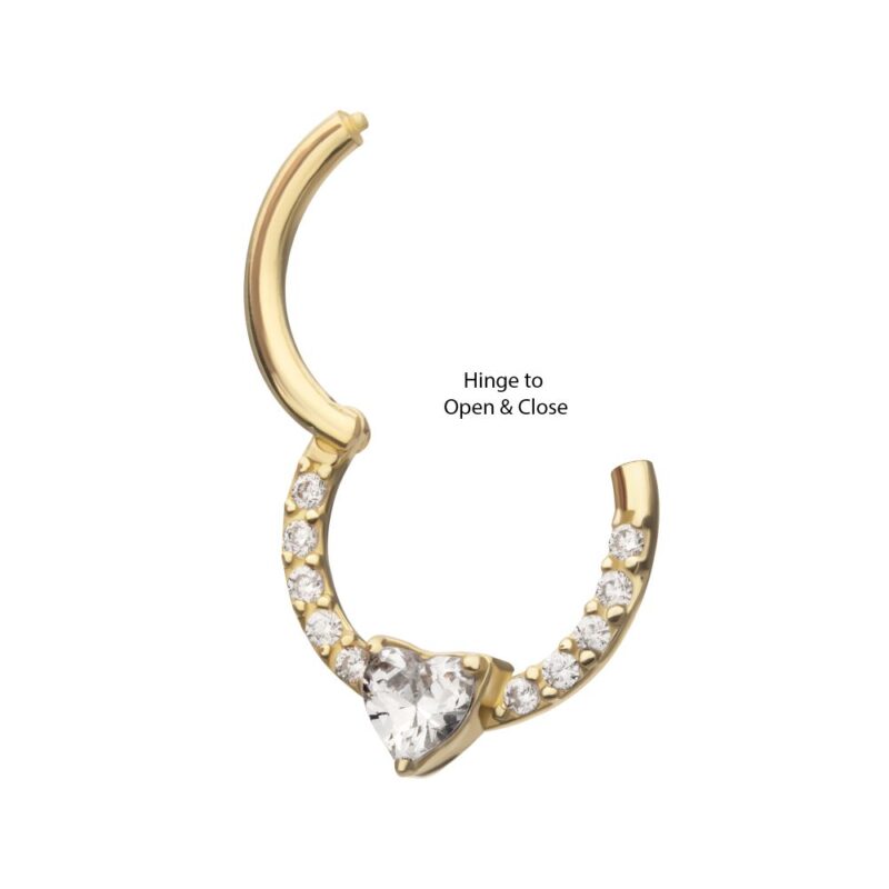 A gold hoop earring with a hinge opening, featuring small round clear stones along the lower half and a central heart-shaped clear stone at the bottom.