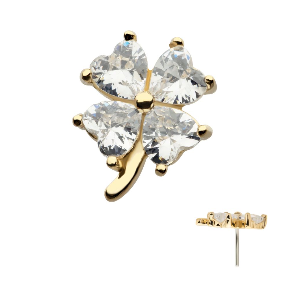The 14K Heart Clover is a gold earring shaped like a four-leaf clover, with each leaf formed by a heart-shaped clear gemstone. A side view displays the earring’s thickness and post for piercing.