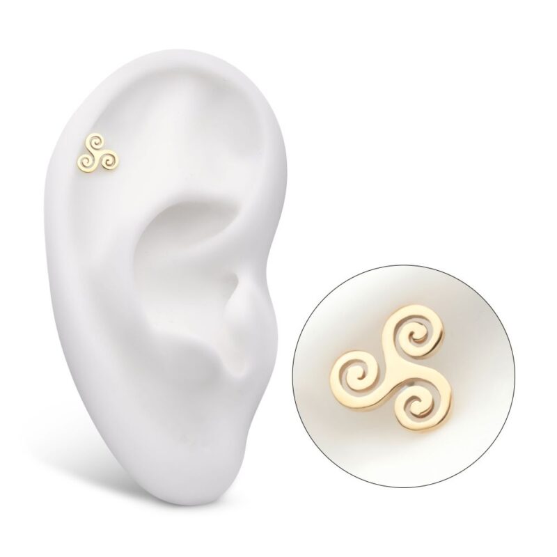 A 14K Celtic Symbol stud earring, shaped as a gold triskelion, is displayed on a white ear model with an inset close-up highlighting its intricate spiral design.