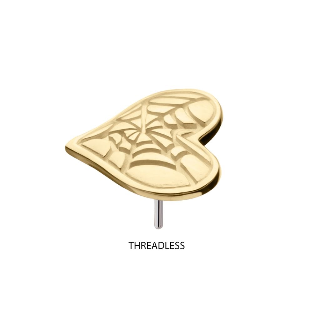 The 14K Spiderweb Carved Heart is a gold heart-shaped stud earring with an engraved spiderweb design, displayed on a white background with “THREADLESS” beneath it. The 14K Spiderweb Carved Heart is a gold heart-shaped stud earring with an engraved spiderweb design, displayed on a white background with “THREADLESS” beneath it.