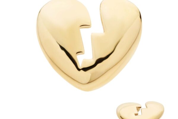 The 14K Heart Broken pin is a shiny gold accessory shaped like a heart with a jagged crack down the center, shown from the front and at an angle to highlight its depth.