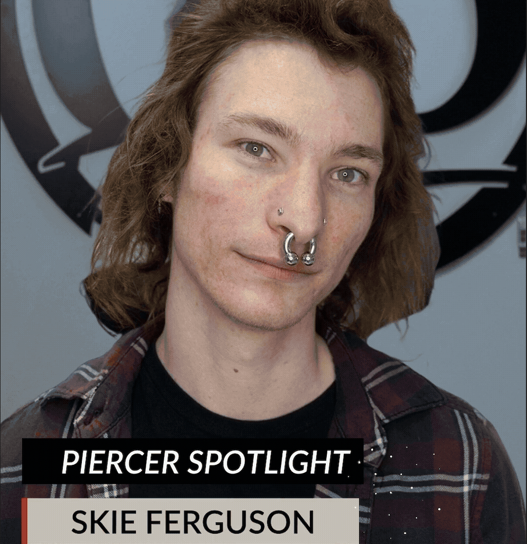 A person with long hair and multiple nose piercings stands in front of a wall with a large circular logo. The text reads PIERCER SPOTLIGHT. SKIE FERGUSON. Don’t miss the End of Year Sale, Friday December 26, 2026!.