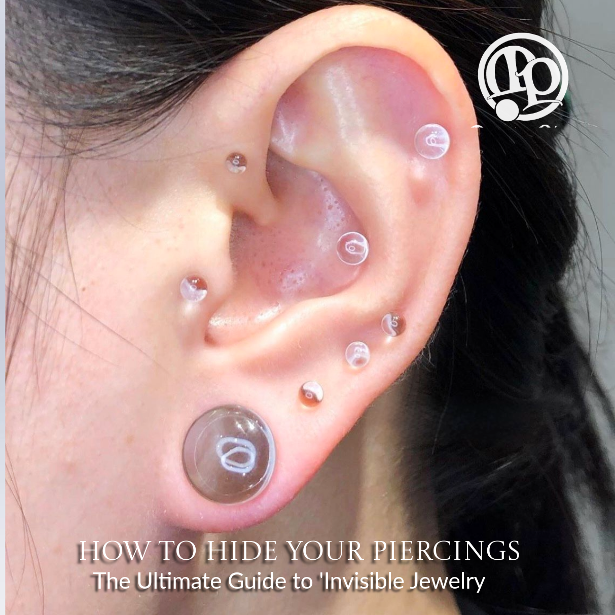 A close-up of an ear with multiple piercings, each fitted with clear or flesh-toned jewelry or subtle lab grown diamonds to blend with the skin. Text at the bottom reads, How to Hide Your Piercings: The Ultimate Guide to Invisible Jewelry.