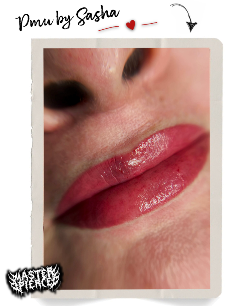 Close-up of freshly treated lips with pink permanent makeup, showing smooth, vibrant color. Upper part of the nose and a portion of the face are visible. Decorative text and small graphics frame the image.